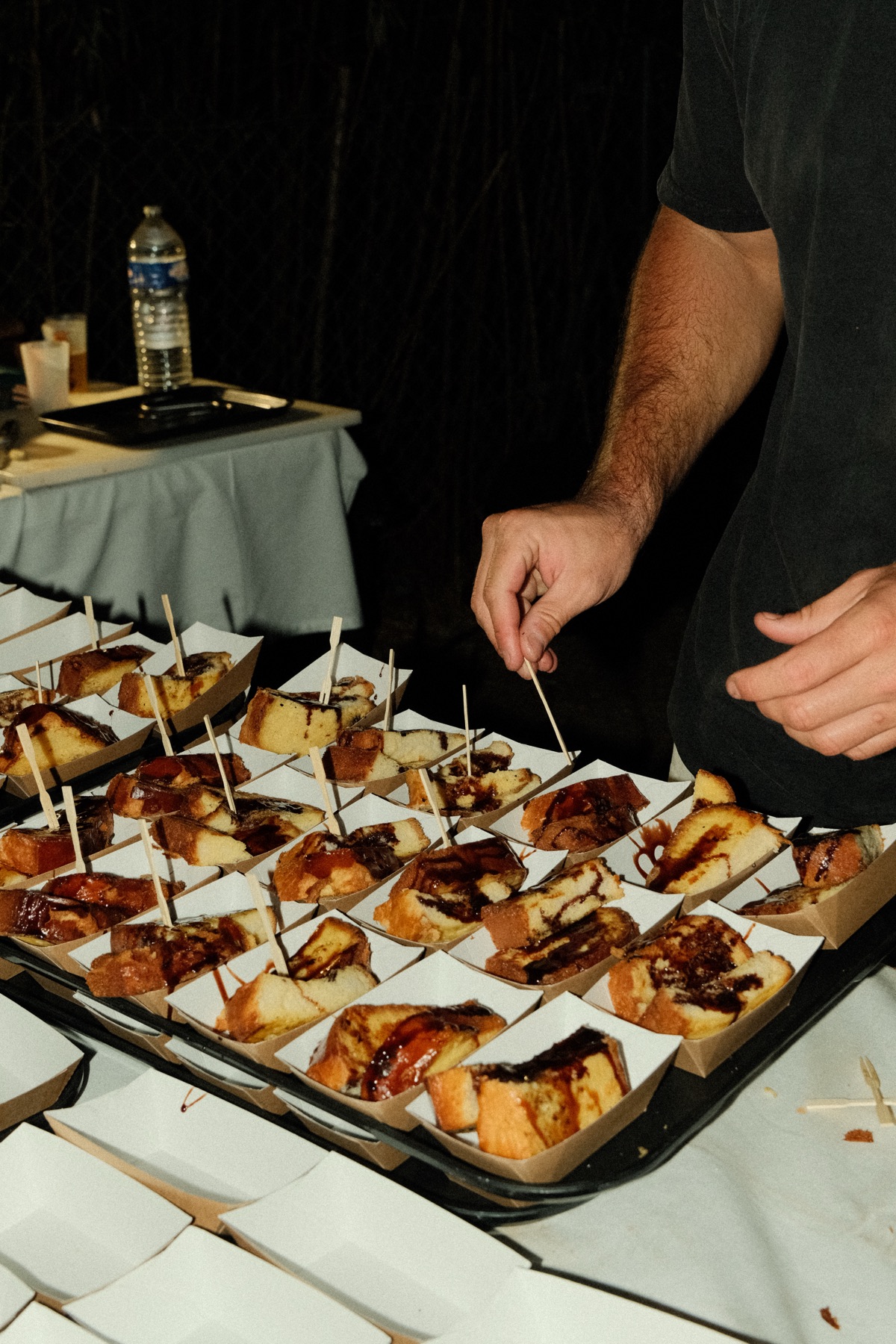 Mains dressant des brochettes et canapés lors d'une prestation Maison Gomary